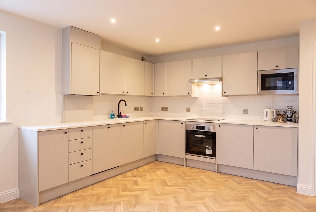 Shared flat kitchen with cream units, oven, hob, microwave and kettle